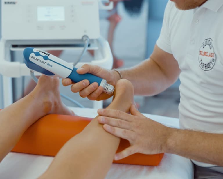 Shockwave therapy being applied to the lower leg at PhysiPro